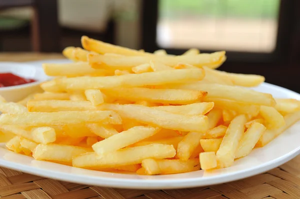 Pommes frites i en hvid plade - Stock-foto