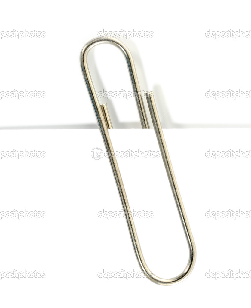 close up of a metal paper clip and paper on white background