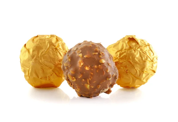Bonbons au chocolat sucré enveloppé dans une feuille d'or isolé sur blanc b — Photo