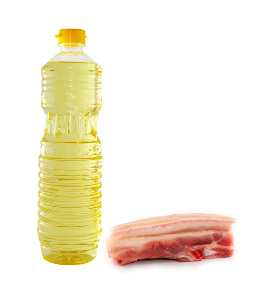 Olio vegetale in imbottigliatore di plastica e carne di maiale cruda — Foto Stock