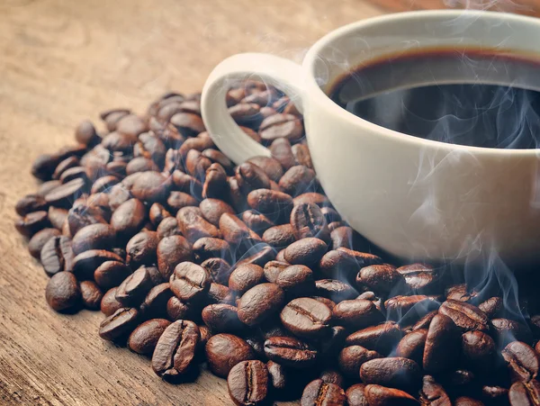 Smoke and roasted coffee  on grunge wooden background — Stock Photo, Image