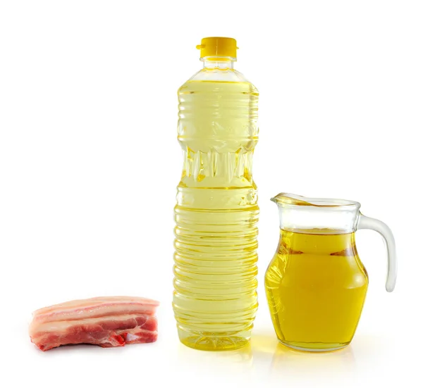 Schmalzöl in einer Plastikflasche und einem Glas auf weißem Hintergrund — Stockfoto