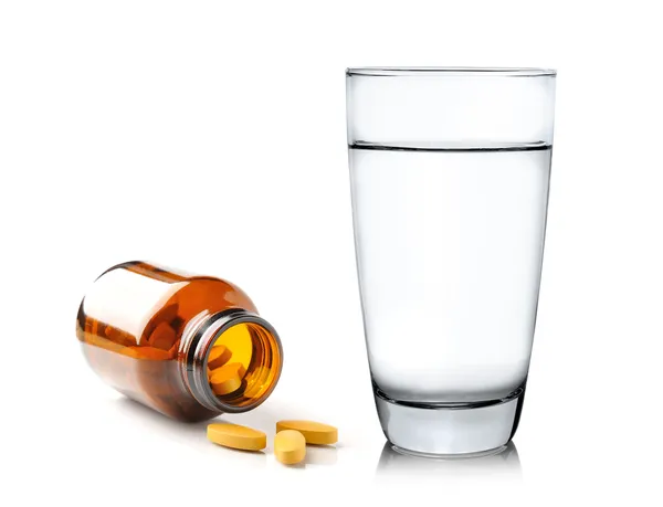 Pills from bottle and Glass of water — Stock Photo, Image