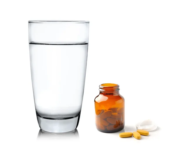 Pills from bottle and Glass of water — Stock Photo, Image