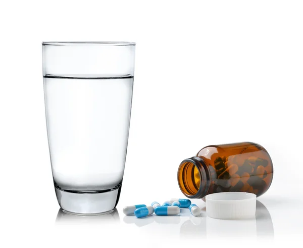 Glas Wasser Medizin Flasche und Pillen isoliert auf weißem Rücken — Stockfoto