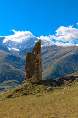 Dağlık ve karla kaplı tepelere bakan eski bir gözetleme kulesi..