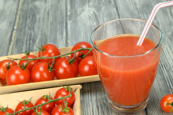 Bir Bardak Pipetli Domates Suyu Yakındaki Ahşap Tepsilerde Bir Yığın — Stok fotoğraf