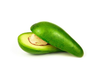 İkiye bölünmüş bir avokado ve ikiye bölünmüş bir kemik. Beyaz arkaplanda izole.