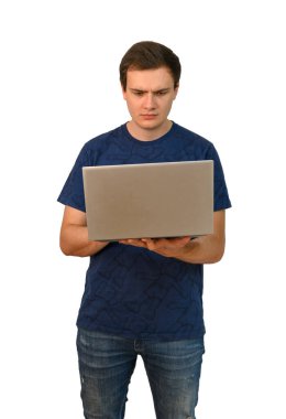 Genç ve çekici bir adam bir elinde dizüstü bilgisayar tutuyor ve düşünceli bir bakışla ekrana bakıyor. Beyaz arkaplanda izole.