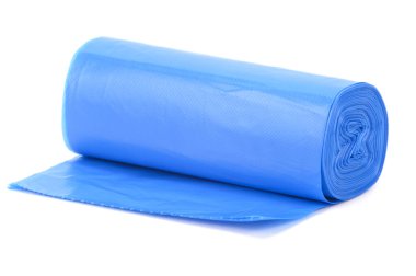 Bir rulo mavi plastik çöp torbası, hafifçe yatay bir yüzeye yuvarlanmış. Beyaz arkaplanda izole.
