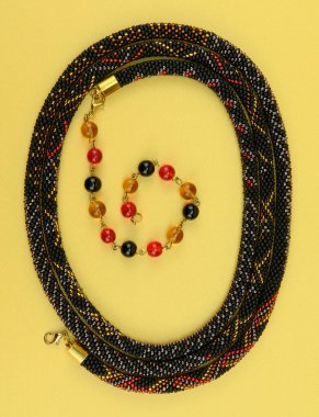 Kadın mücevherleri. Kolye, her iki ucunda süs cam boncukları olan çok renkli boncuklardan örülmüş. Sarı arkaplanda izole edilmiş.