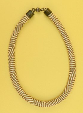 Kadın mücevherleri. Manyetik kapaklı çok renkli boncuklardan örülmüş bir kolye. Sarı arkaplanda izole edilmiş.