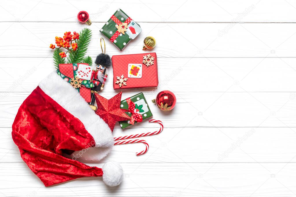 Handmade wrapped red, green gift boxes decorated with ribbons, snowflakes and numbers, Christmas decorations and decor in hat on white table Xmas advent calendar concept Top view Flat lay Holiday card.