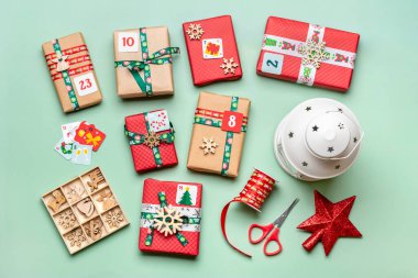 El yapımı kırmızı, yeşil hediye kutuları. Kurdeleler, kar taneleri ve numaralarla dekore edilmiş, Noel süslemeleri ve yeşil masa süsleri. Xmas takvimine yeni bir takvim konsepti..