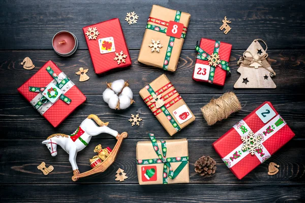 Fatto a mano avvolto rosso, scatole regalo verde decorato con nastri, fiocchi di neve e numeri, decorazioni natalizie e arredamento sulla tavola concetto di calendario dell'avvento di Natale Top view Flat lay Holiday card — Foto Stock