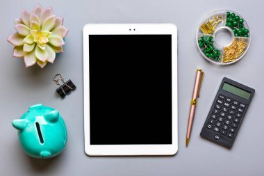 Siyah ekranlı dijital tablet, domuz kumbarası, hesap makinesi, sulu, gri arkaplan üzerine not defteri iş dünyası, sigorta, teknoloji konsepti Üst Düzey Düzey iş yeri