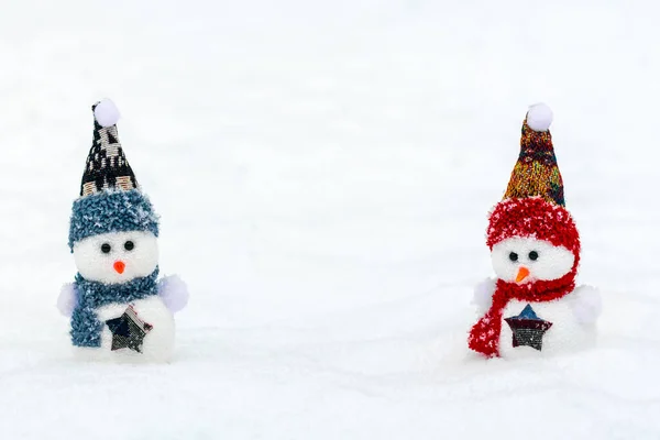 Merry christmas and happy new year greeting card with copy space Happy two little snowmen in red, blue cap and scarf standing in winter snow background Xmas fairytale Hello January, February concept — стокове фото