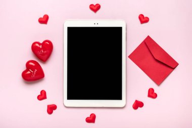 digital tablet for chooses gifts, makes purchase, envelope, red hearts on pink table Top view Flat lay Holiday shopping list, Happy Valentines day, party, online shop concept Mock up