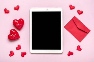 digital tablet for chooses gifts, makes purchase, envelope, red hearts on pink table Top view Flat lay Holiday shopping list, Happy Valentines day, party, online shop concept Mock up