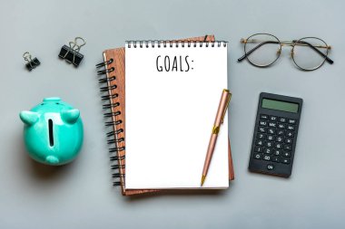 Not defteri, domuz kumbarası, hesap makinesi, gözlükler, gri zemin üzerine kalem finansal planlama, Yeni Yıl konsepti için hedefler Üst Düzey Yatay Finans eğitimi ve stratejileri yer kopyala