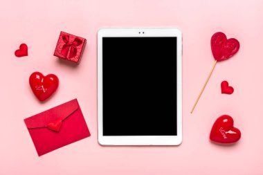Hediye seçmek için tablet, satın alma, zarf, kutu, pembe masadaki iki kırmızı kalp düz konum tatil alışveriş listesi, Sevgililer Günü, parti, çevrimiçi alışveriş konsepti.