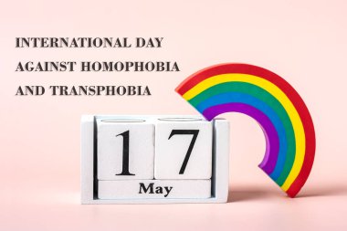 Gökkuşağı LGBT sembolü, Pembe arka planda izole edilmiş takvim 17 Mayıs - Homofobiye Karşı Uluslararası Gün, Ulaşım fobisi ve Biobi tebrik kartı konsepti.