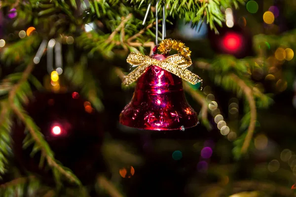 Yeşil dalların ve ışıkların arka planında Noel oyuncakları — Stok fotoğraf