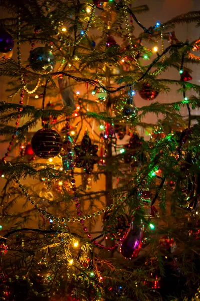 New Years toys against the background of green branches and lights — Stock Photo, Image