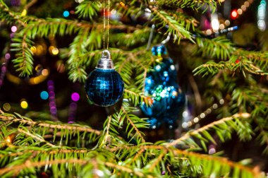 Yeni yıl ya da Noel, şık dekore edilmiş ladin yakın plan - yeşil dallar ve ışıkların arka planına karşı Noel oyuncakları.