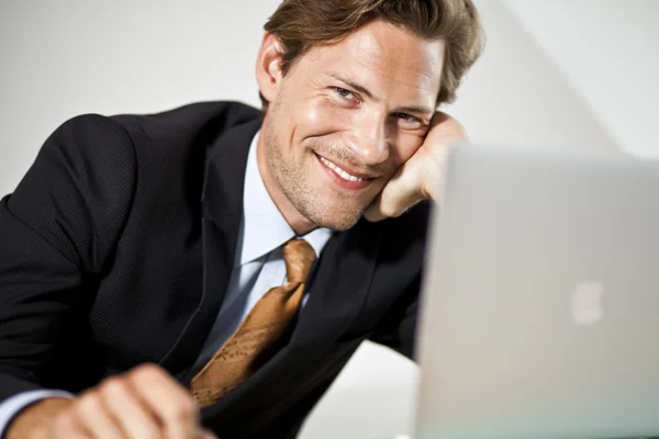 Sorrindo homem de negócios caucasiano usando laptop — Fotografia de Stock