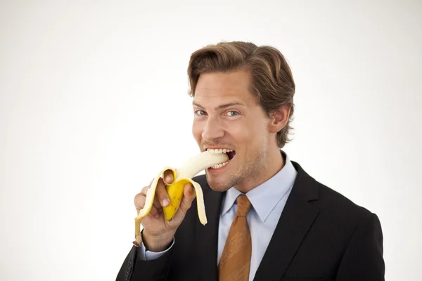 Hombre de negocios saludable comiendo plátano — Foto de Stock