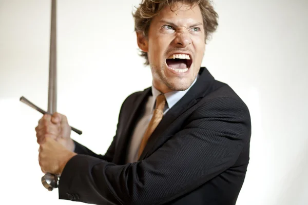 Crazy businessman attacking with a sword — Stock Photo, Image
