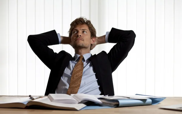 Wondering businessman leaning back in his chair — Stock Photo, Image