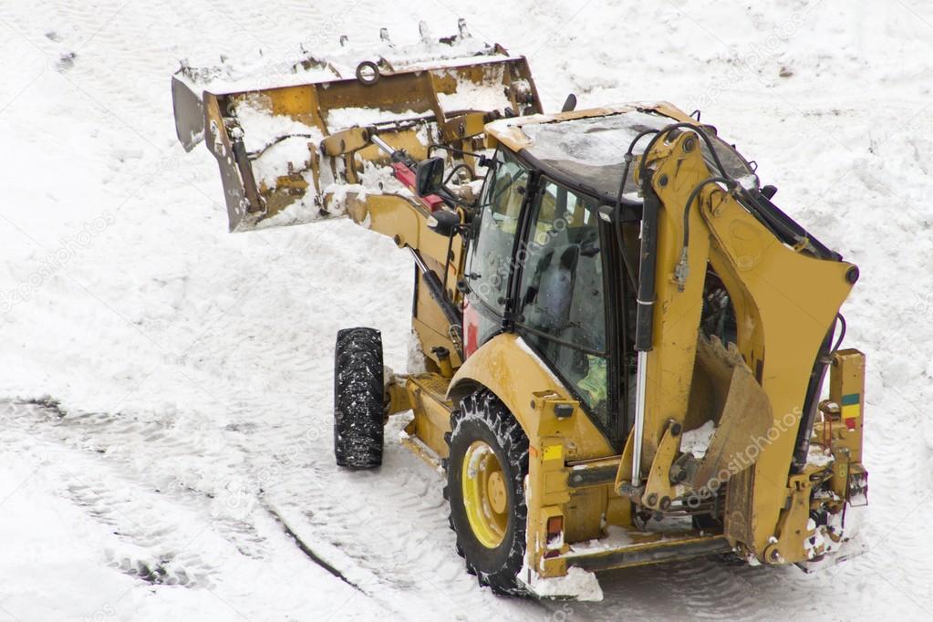 An excavator cleans snow blocked parking