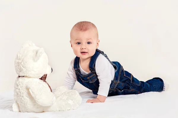 O menino brinca com um ursinho de pelúcia — Fotografia de Stock