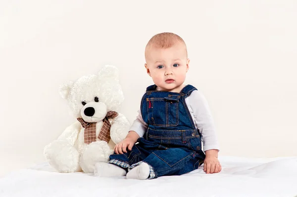 Мальчик играет с плюшевым медведем — стоковое фото