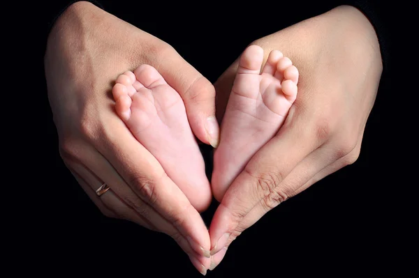 Benen van het kind en de handen van Mama — Stockfoto