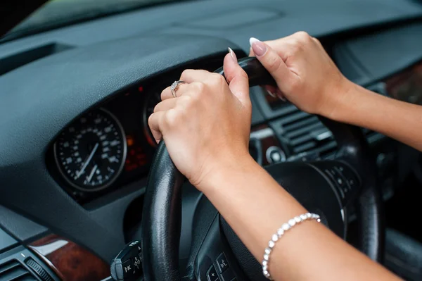 Mujer manos sobre un volante en el coche —  Fotos de Stock