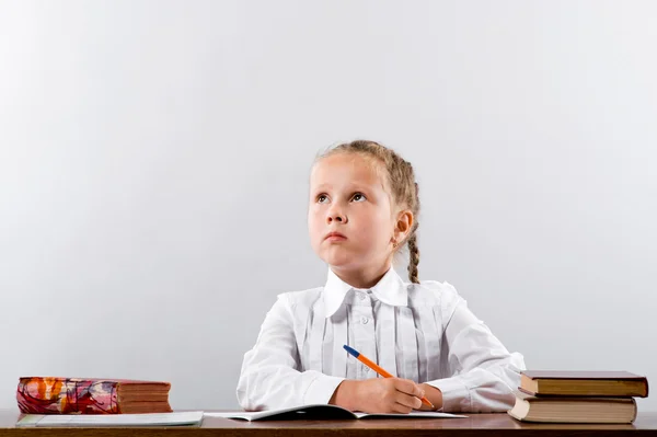 Skolflicka tänker över den svåra uppgiften — Stockfoto