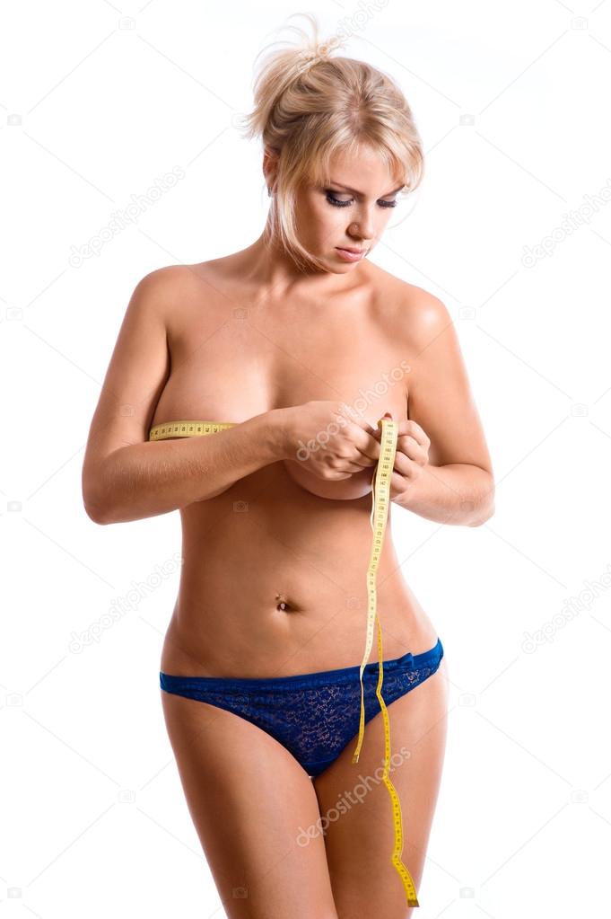 Woman measuring her breast with a yellow measuring tape
