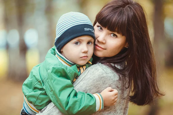 Zbliżenie portret kobiety z synem w parku jesień — Zdjęcie stockowe