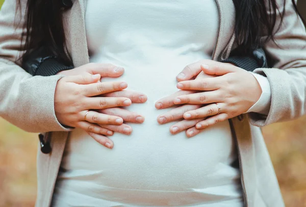 Le mani di uomo abbracciano una pancia della donna incinta — Foto Stock