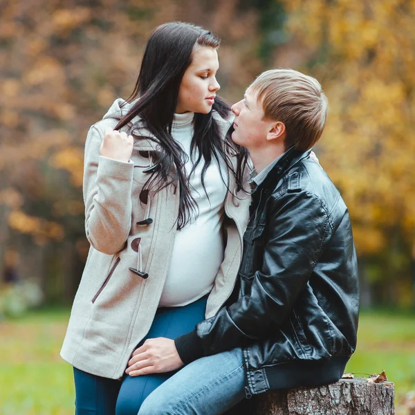 Man and his pregnant wife walks in the autumn park — Stock Photo, Image