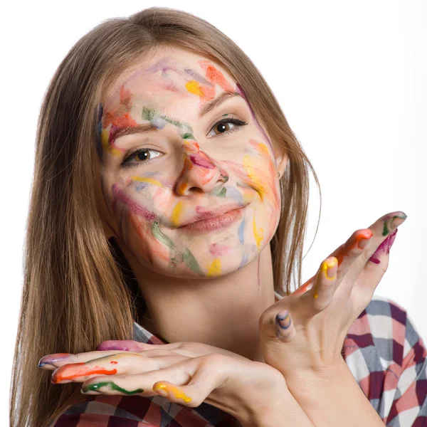 Chica con la cara pintada y las manos en pinturas de colores —  Fotos de Stock