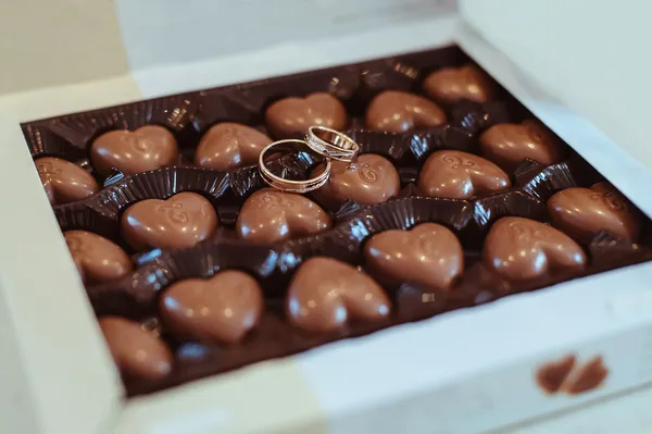Snubní prsteny a čokoláda — Stock fotografie