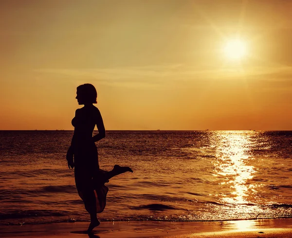 Chica en hermosa playa durante la puesta del sol — Foto de Stock