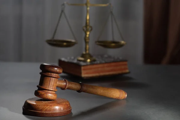 黑暗背景下在法庭或执法办公室桌上的木制法官槌和法律与正义的象征 — 图库照片