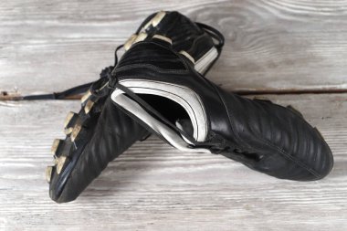 Ahşap duvarda asılı bir çift futbol ayakkabısı. Futbol kariyerinin sonu.
