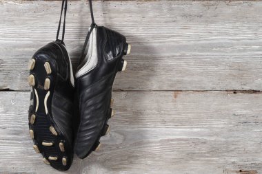 Ahşap duvarda asılı bir çift futbol ayakkabısı. Futbol kariyerinin sonu.