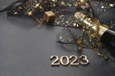 Yeni yıl konsepti, parlak ışık ve şampanya şişesiyle, altın sarısı arka plan